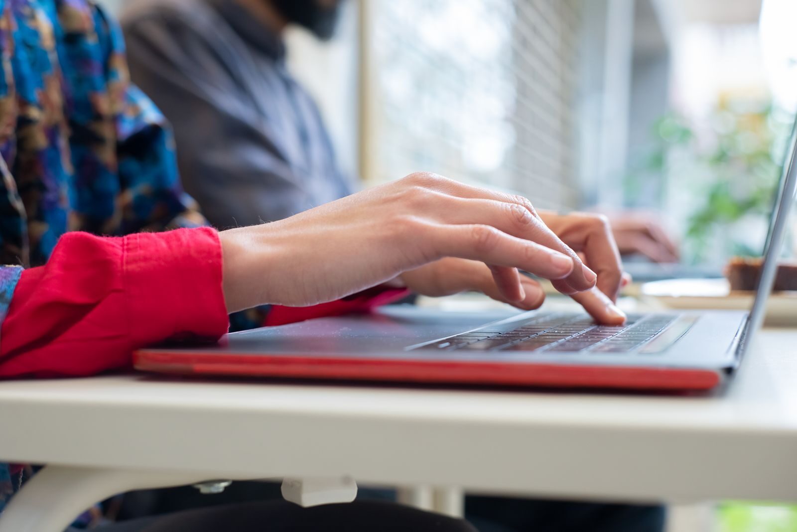 Person typing on a laptop indoors in Portugal, showing productivity and technology use.