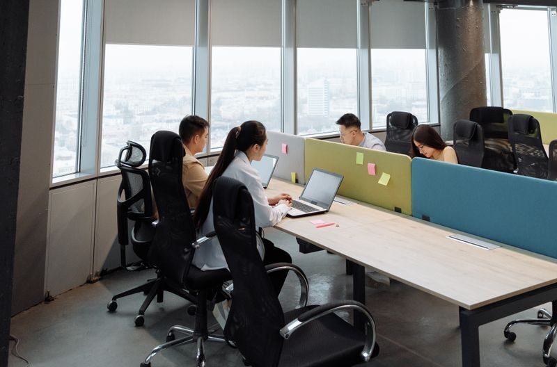 Spacious contemporary office space with employees working on laptops in a high-rise building.
